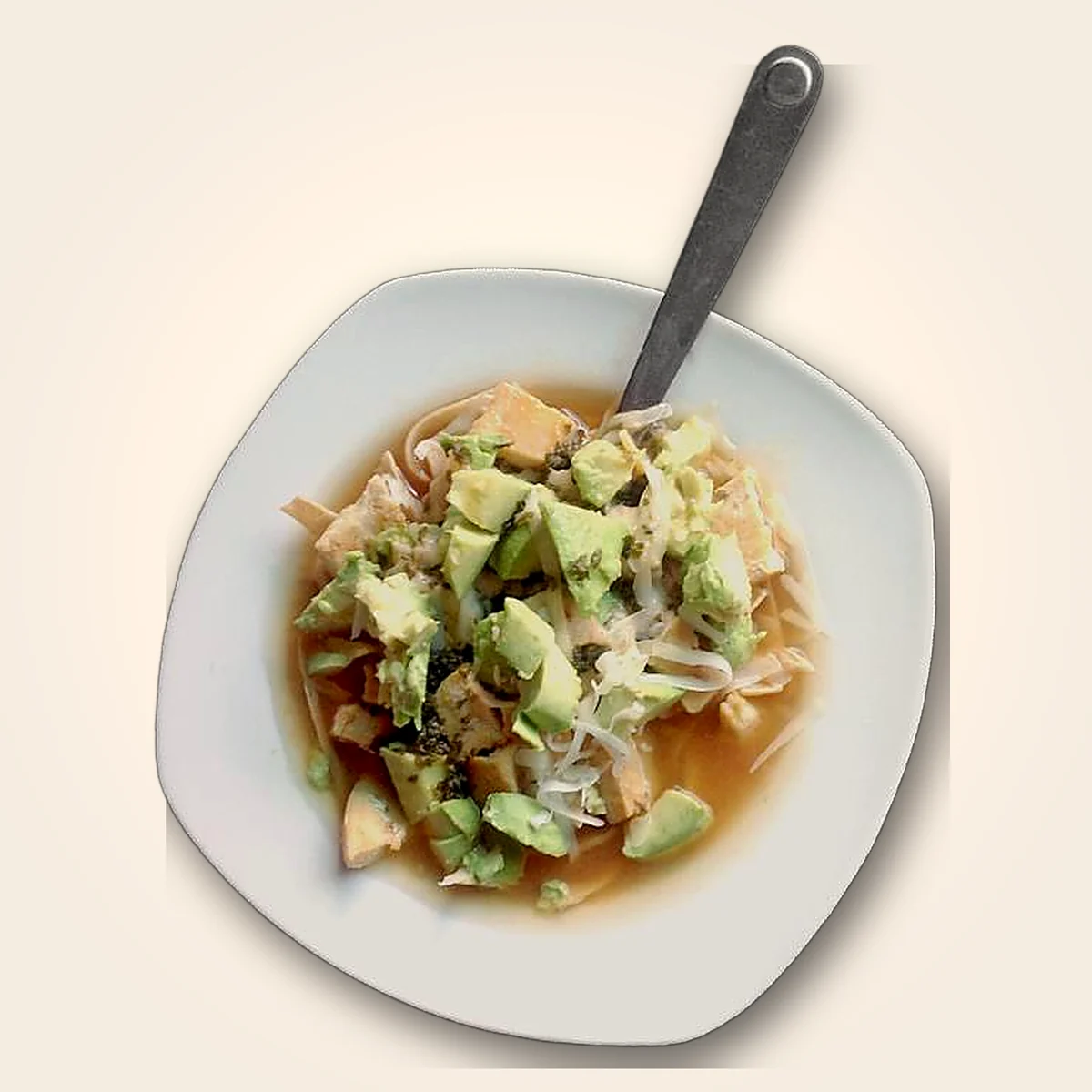 A bowl of tortilla soup made with Chololoy®: chicken, avocado, crispy tortilla strips and cheese